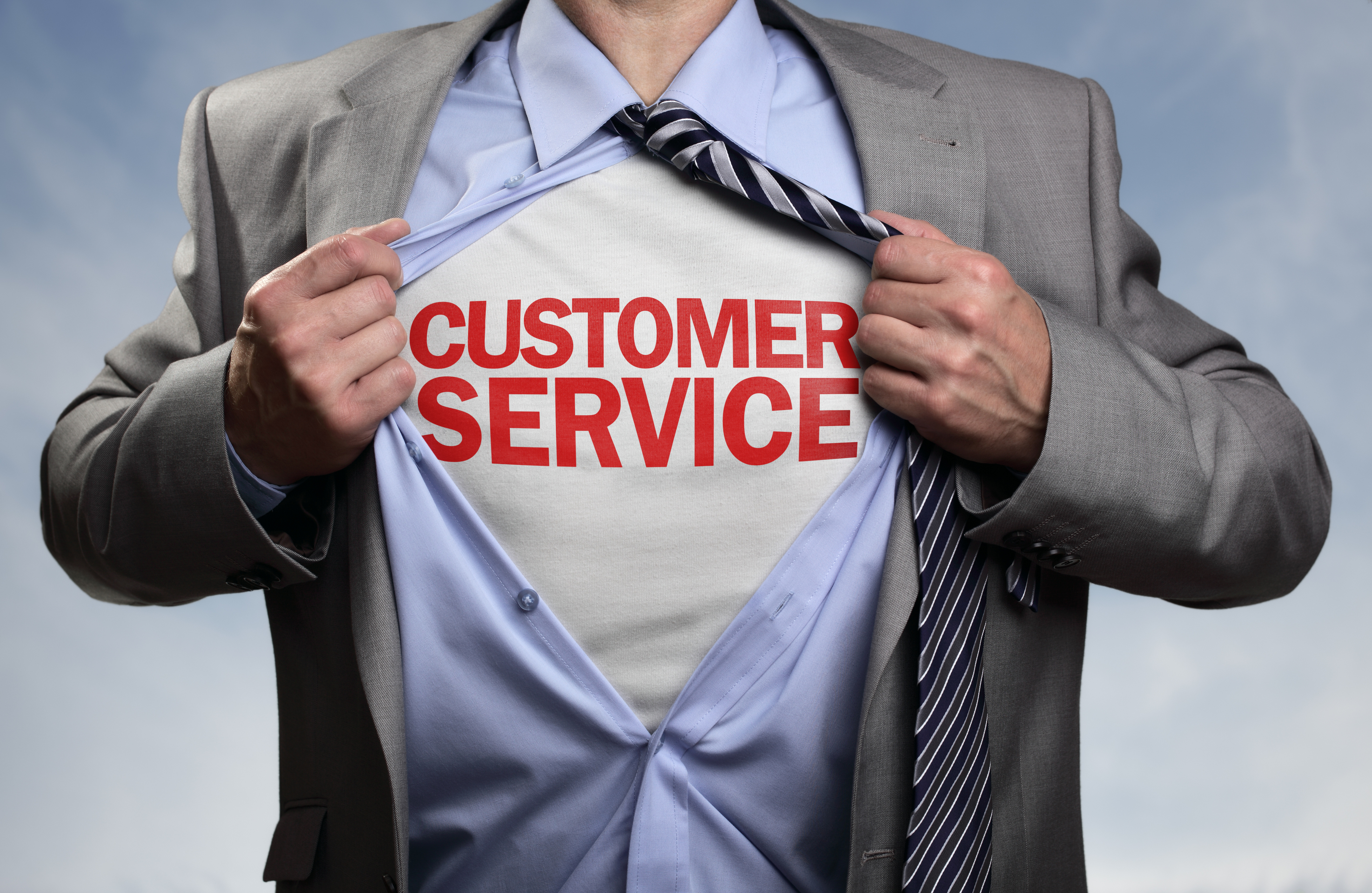 Businessman in classic superhero pose tearing his shirt open to reveal t shirt with customer service concept for assistance, contact us, helpdesk, helpline and business support